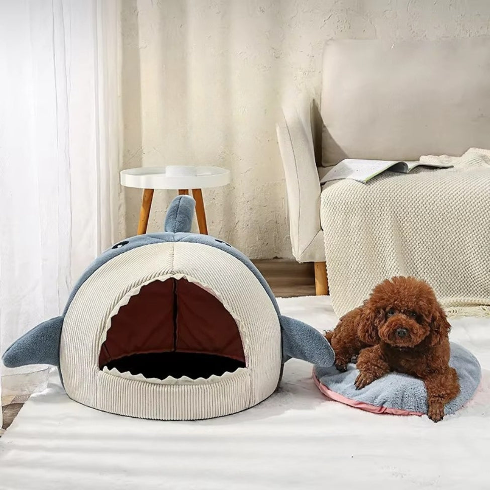 Petit chien allongé sur le coussin d’une niche chien intérieur
