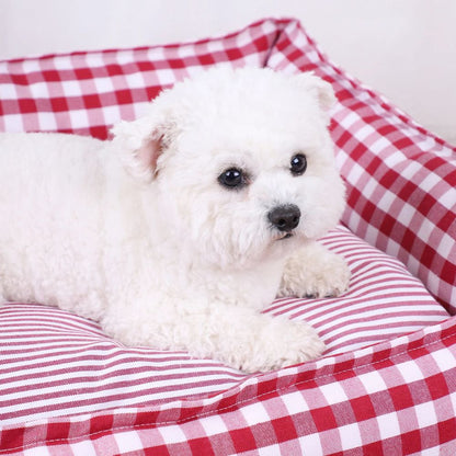 Gros plan d’un bichon installé dans un panier déhoussable pour chien à motif vichy