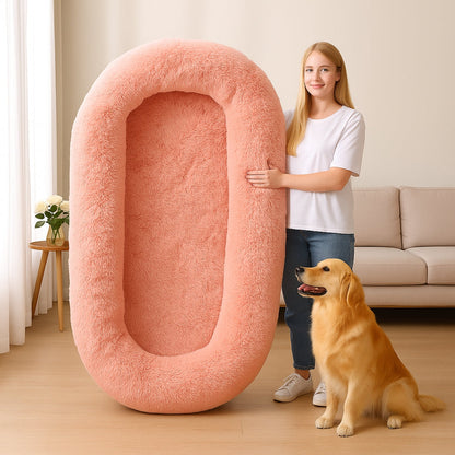 Golden se trouve près d'une fille qui tient debout un lit chien de grande taille rose