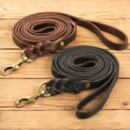 laisse cuir chien noir et marron présentées sur un fond en bois clair