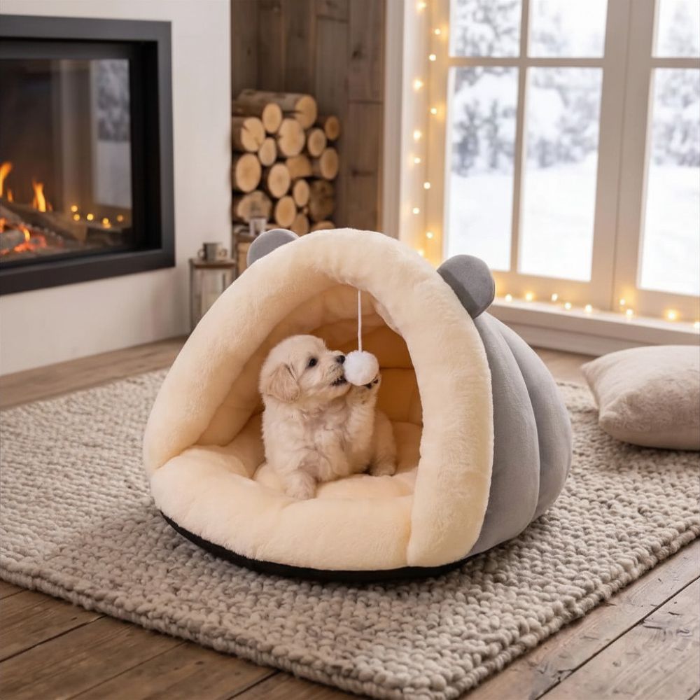 Chiot jouant avec le pompon dans une niche chien intérieur grise
