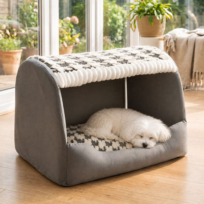 Bichon dort tête posée sur le rebord d'une niche pour chien intérieur grise