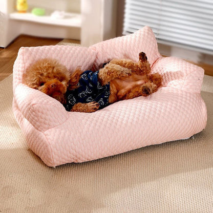 Caniche allongé paisiblement sur un canapé chien Oslo rose, doux et raffiné