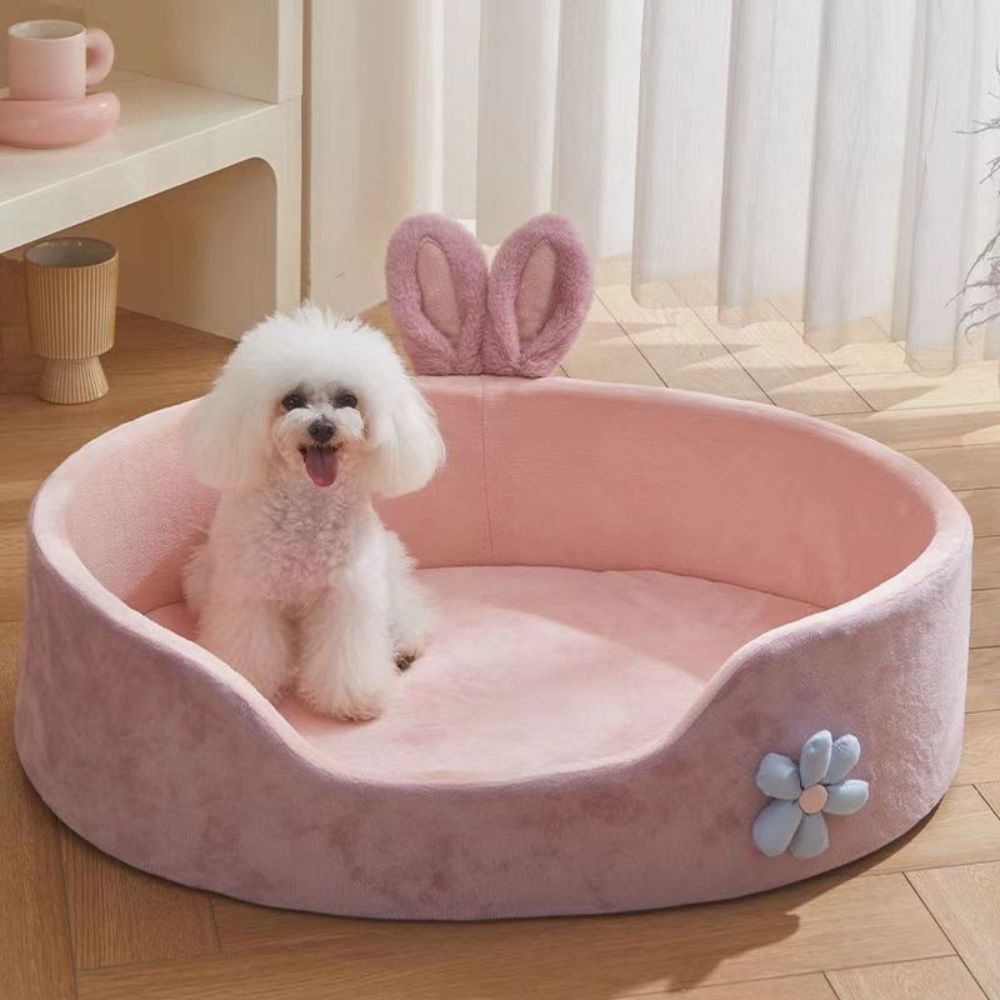 Caniche assis dans un panier chien design rose aux oreilles décoratives