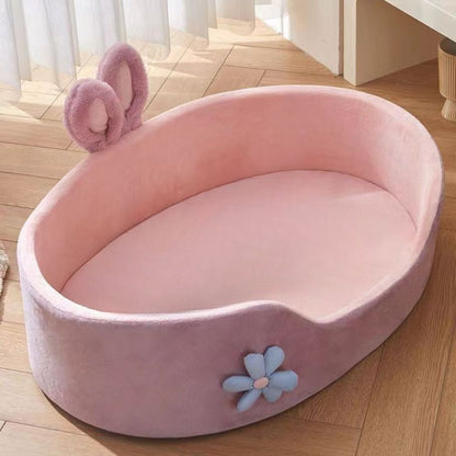 Panier chien design ovale rose avec oreilles en tissu et fleur décorative bleue