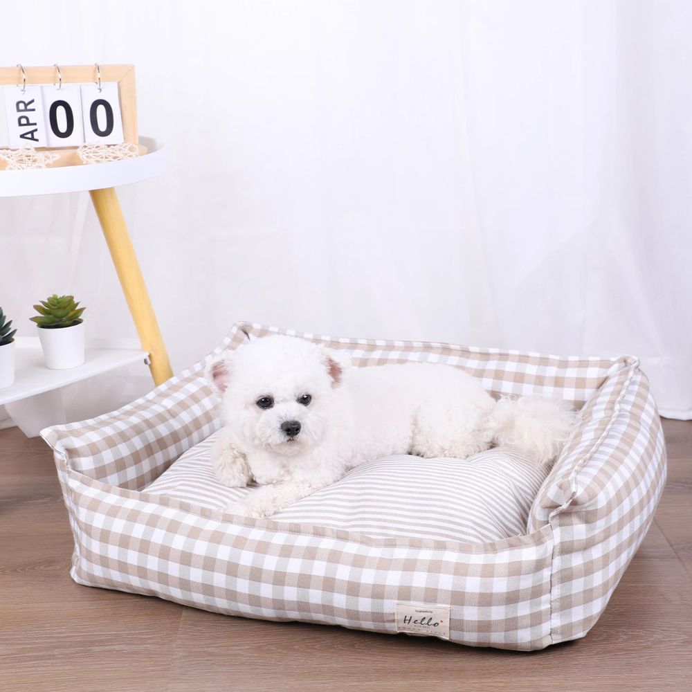  Bichon allongé dans un panier déhoussable pour chien beige avec rebords doux 