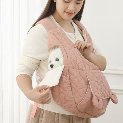 Bichon dans un sac ventral pour chien avec une ouverture latérale pour plus de confort
