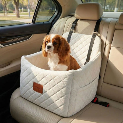 king charles dans un siège auto pour chien beige observant l’extérieur lors d’un transport en voiture apaisant