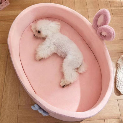 Chien allongé de tout son long dans un panier chien design rose, vue en plongée