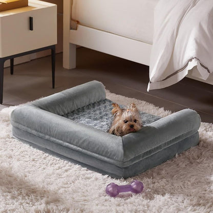 Petit Yorkshire reposant dans un canapé lit pour chien aux bords surélevés rassurants