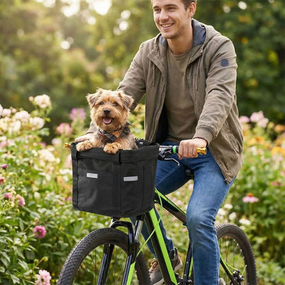 petit Yorkshire assis dans un panier pour chien à vélo pendant une promenade dans un jardin